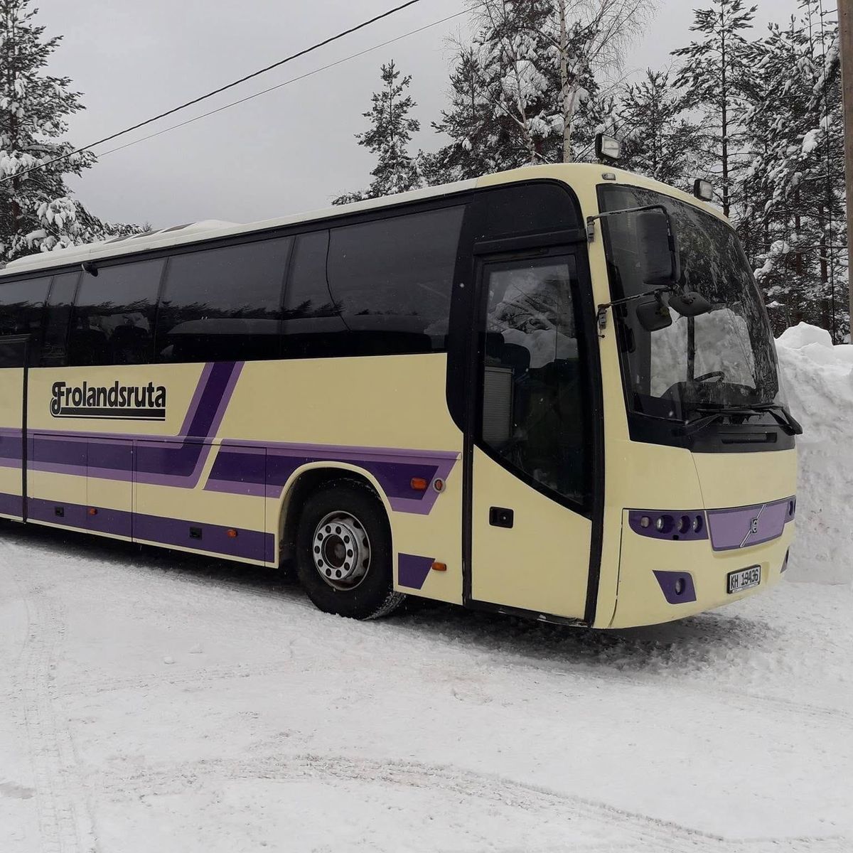 Frolandsruta-bussen i krem og lilla på en brøytet plass med snø rundt